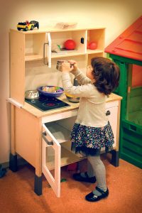 zabawkowa kuchnia i dziewczynka