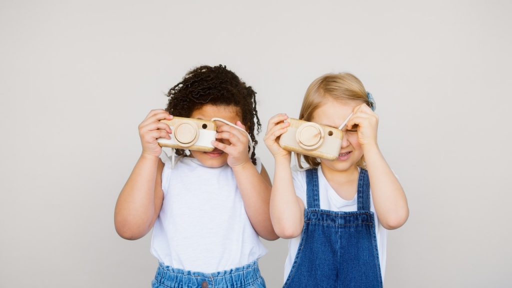 Dwie dziewczynki trzymające aparaty dla dzieci